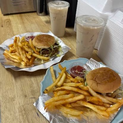 Two burgers with fries and two cups of horchata