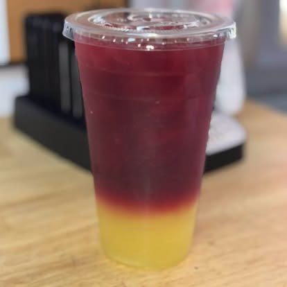 A layered drink of red jamaica over yellow piña