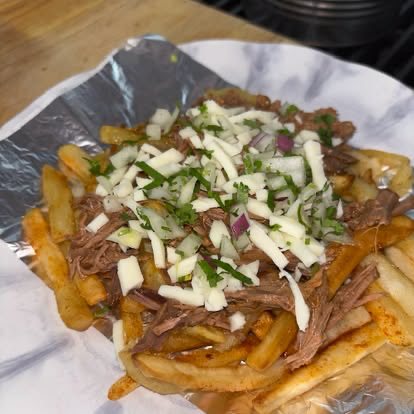 Crispy fries loaded with shredded meat, white onion and cilantro
