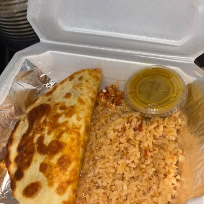 A golden quesadilla with Mexican rice and a cup of green salsa